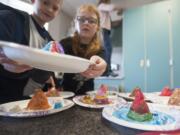 Harney Elementary School students prepare model volcanoes to erupt via a chemical reaction between baking soda and vinegar on Monday.