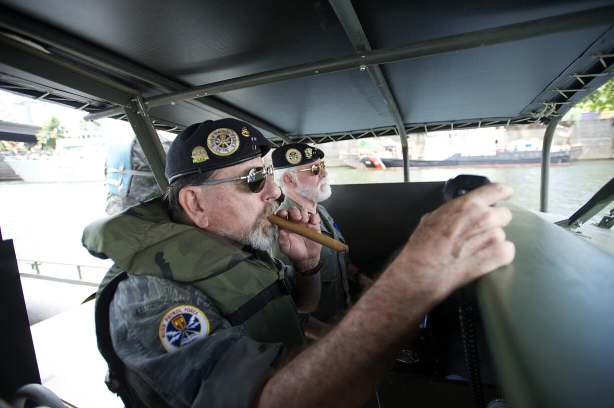 Alan Stephens, left, and Stephen Morrison, members of the Gamewardens Association's Northwest Chapter, escort the Navy guided missile cruiser USS Chosin up the Willamette River during Wednesday's Rose Festival Fleet Week activities.