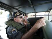 Alan Stephens, left, and Stephen Morrison, members of the Gamewardens Association's Northwest Chapter, escort the Navy guided missile cruiser USS Chosin up the Willamette River during Wednesday's Rose Festival Fleet Week activities.