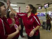 Fort Vancouver High School senior Tamika Taylor high-fives her teammates after bowling in the baker game against Prairie on Monday.