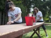 Volunteers Stefanny Caballero, left, and Sierra Smith paint a picnic table to spruce up the YWCA in Vancouver on Wednesday as part of the United Way's annual &quot;Day of Charitable Giving.&quot;