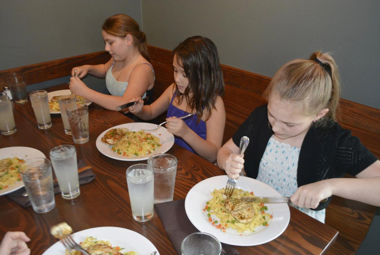 Washougal: Hathaway Elementary fifth-graders Danielle Melton, from left, Braelinn Reyes-Martinez and Paris Bendele enjoy a lunch field trip to learn about table manners as part of the Young Women in Action program.