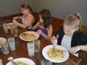 Washougal: Hathaway Elementary fifth-graders Danielle Melton, from left, Braelinn Reyes-Martinez and Paris Bendele enjoy a lunch field trip to learn about table manners as part of the Young Women in Action program.