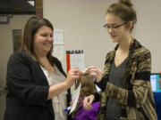 Contemporary World Problems teacher Elizabeth Prager hands senior Abby Judge an &quot;I voted&quot; sticker after submitting her ballot online on Thursday in the Washington secretary of state's mock election at Fort Vancouver High School.