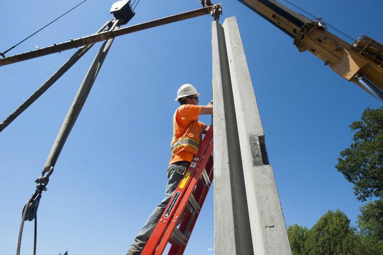 Carl Brown works on Highway 502 construction near Dollars Corner in Vancouver on Monday, the same day the Legislature unveiled a comprehensive transportation package that will keep road construction projects continuing for the next two decades.