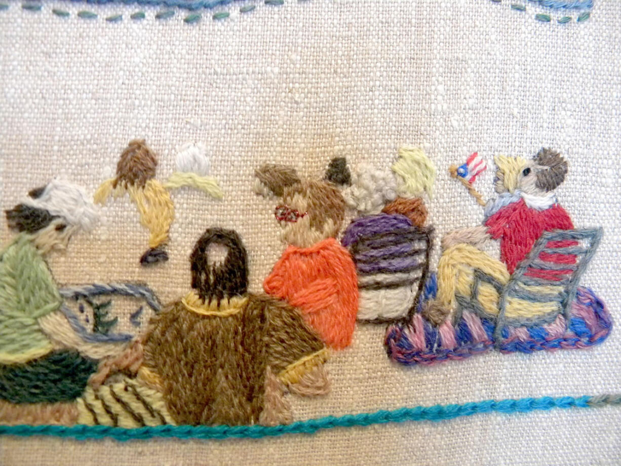 Eileen Ono, center in the salmon-colored blouse, stitches on a panel of the Fort Vancouver Tapestry with other women in the tapestry's image of a July 4 fireworks show.