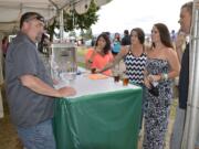 Washougal: Mark Zech, left, of Mill City Brew Werks in Camas serving guests at the first ever Weird Beer on the River fundraisers in Washougal on July 10 and 11.