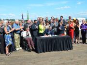 Office of the Governor
Sen. Don Benton, R-Vancouver, in blue shirt and khakis, applauds as Gov. Jay Inslee signs the transportation package into law last week. A few hours earlier, his office had announced he would attend the ceremony to voice his opposition to a &quot;raw deal for Clark County taxpayers and commuters.&quot;