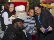 Festival of Trees
Photos by Greg Wahl-Stephens for The Columbian
Shelli Blake, right, works on getting a selfie of the family including Robert Blake, bottom left, Cash? Blake, left, with her dog Peewee and Trevon Blake as they visit with Santa at the Festival of Trees at the Hilton Vancouver Washington in downtown.