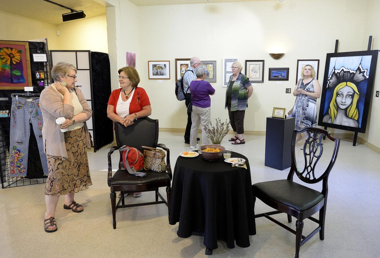 Photos by Amanda Cowan/The Columbian
Linda Andrews-Riggs of Vancouver, left, and Myrna Leija discuss the non-juried -- that is, open to all applicants -- &quot;Art in the Heart&quot; gallery show at Gallery 360 during the Aug. 7 First Friday Art Walk. Top: Art On The Boulevard gallery volunteer Ernie Veach-White, left, chats with Vancouver painter Michael Lindstrom during the art walk. Lindstrom said he and his fellow artists routinely collect one another's work -- both because they love art and because they need to support one another.