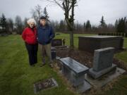 Vancouver residents Jack and Marilyn Johnson stand  next to the grave site, grave marker and bench they purchased in advance at Northwood Park Cemetery in Ridgefield.