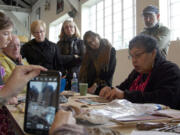 A crowd watches renowned artist Lillian Pitt demonstrate how to make a traditional Native American mask out of clay during a workshop at Pearson Air Museum in Vancouver on Saturday.