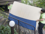 Movers Tim Stanley (L) and Quinten Martinez (R) navigate a box spring up a flight of steps at an apartment complex in Portland Monday August 31, 2015. Census data shows more people moving to Clark County than leaving, as of 2013, with inbound migration being mostly from the Portland area.