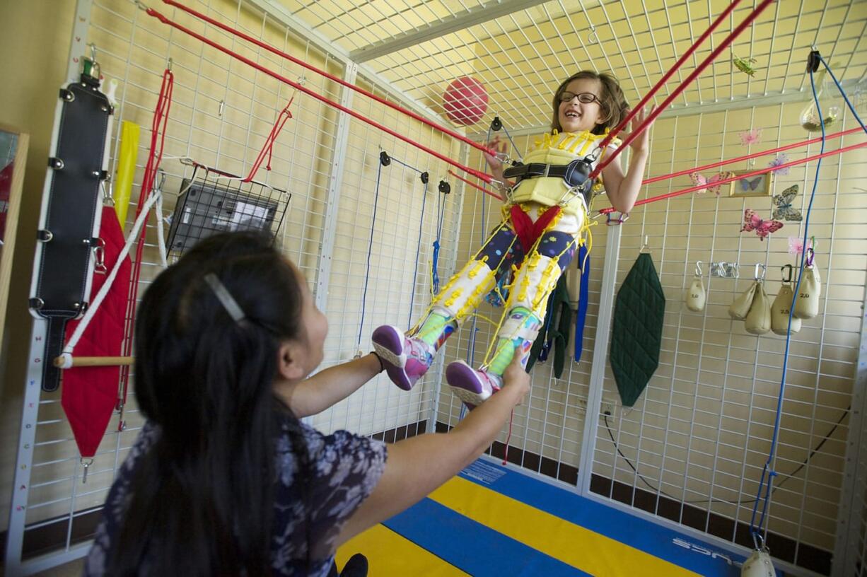 Physical therapist Denise Wentzel works with 6-year-old Olivia Hughes, who has cerebral palsy, during an intensive pediatric therapy session at Innovative Services NW.