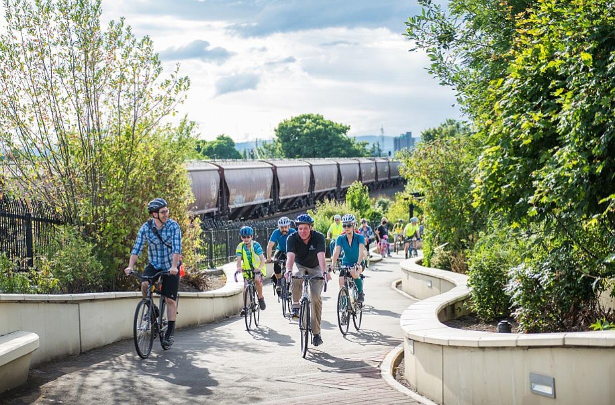 Esther Short: Urban forestry specialist Nick Redmond, center in dark blue, leads the annual Heritage Tree Bike Ride over the State Highway 14 land bridge.