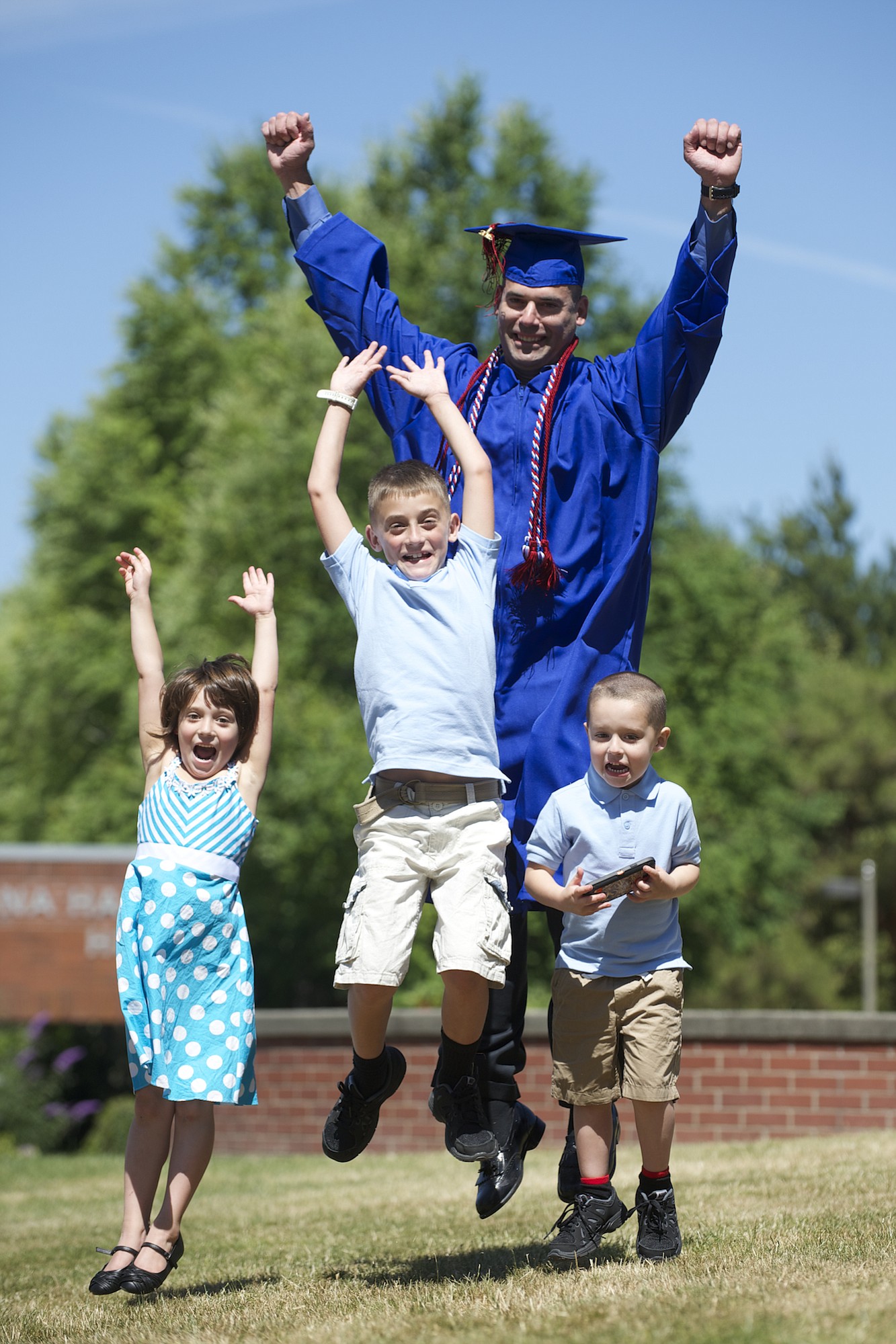 Alex Peraza, with his children, from left, Elsa Aaliyah, 6, Jacob, 8, and Preston, 4, received  his associate of arts degree at Clark College's 79th commencement Thursday night. As a boy, Peraza emigrated from Cuba with his family. He served in the U.S.