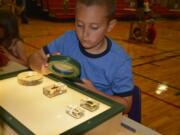 Washougal: Hathaway Elementary School student Dean Cox examines some insects during a summer program at the school hosted by the Oregon Museum of Science and Industry.