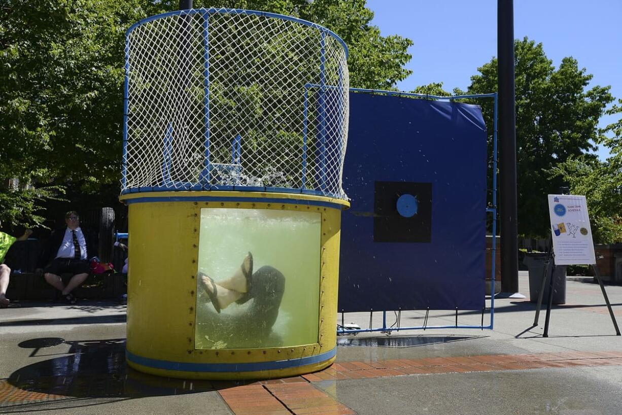 Ariane Kunze/The Columbian
Clark County Auditor Greg Kimsey falls into a dunk tank outside the Public Service Center on July 30. The event put on by Clark County Children's Sharing Project helped raise money for local school supplies.