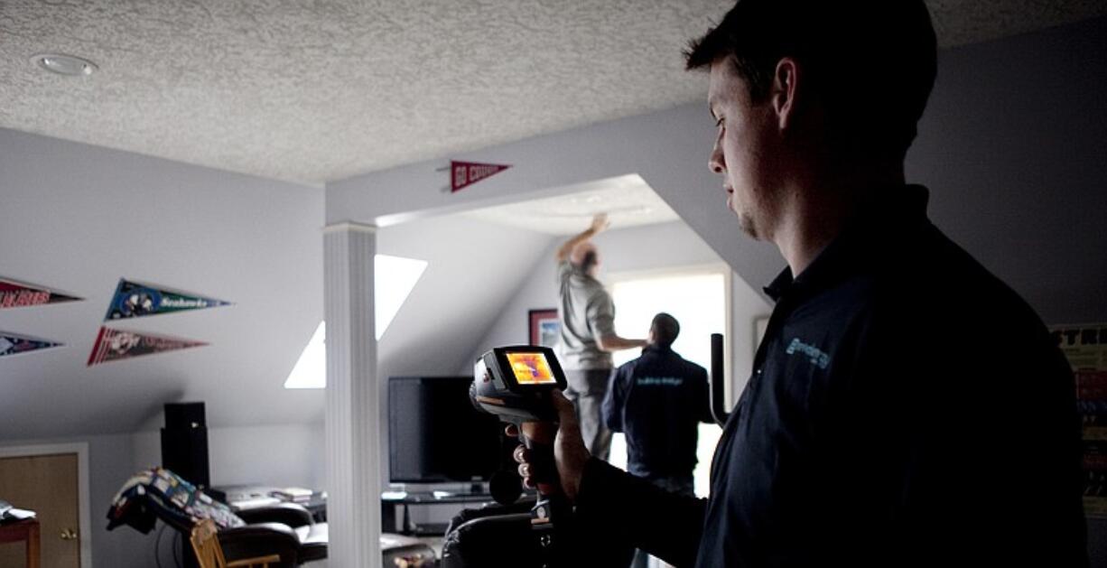 Robert Brierley, owner of Vancouver-based Revival Energy Group, tests a room for cold-air leaks at a home in Vancouver.