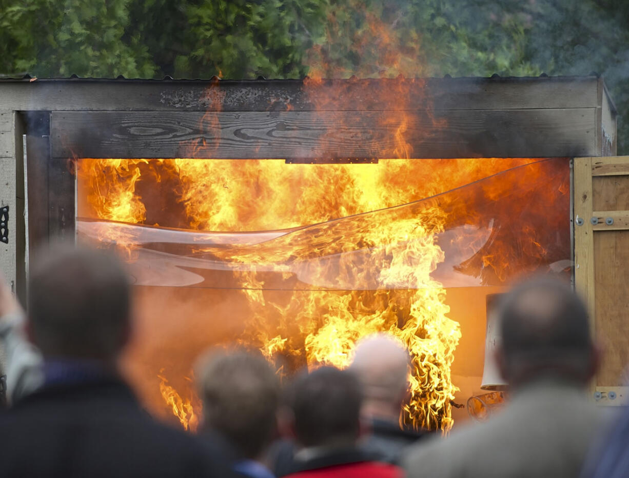 Spectators watch a live-burn demonstration Thursday that was organized by fire officials to show how fire sprinklers work.