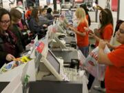 Dawn Leonard, front left, of the Brush Prairie area checks out of Old Navy at the Westfield Vancouver Mall as Mika Smith, right, helps out.