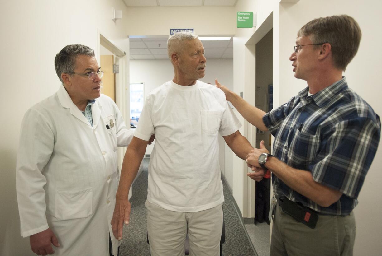 Physical therapist Jeff Gulliford, right, and Dr. David Griffin, left, screen patient Ron Hamilton for balance issues at the Kaiser Permanente Mill Plain medical office.