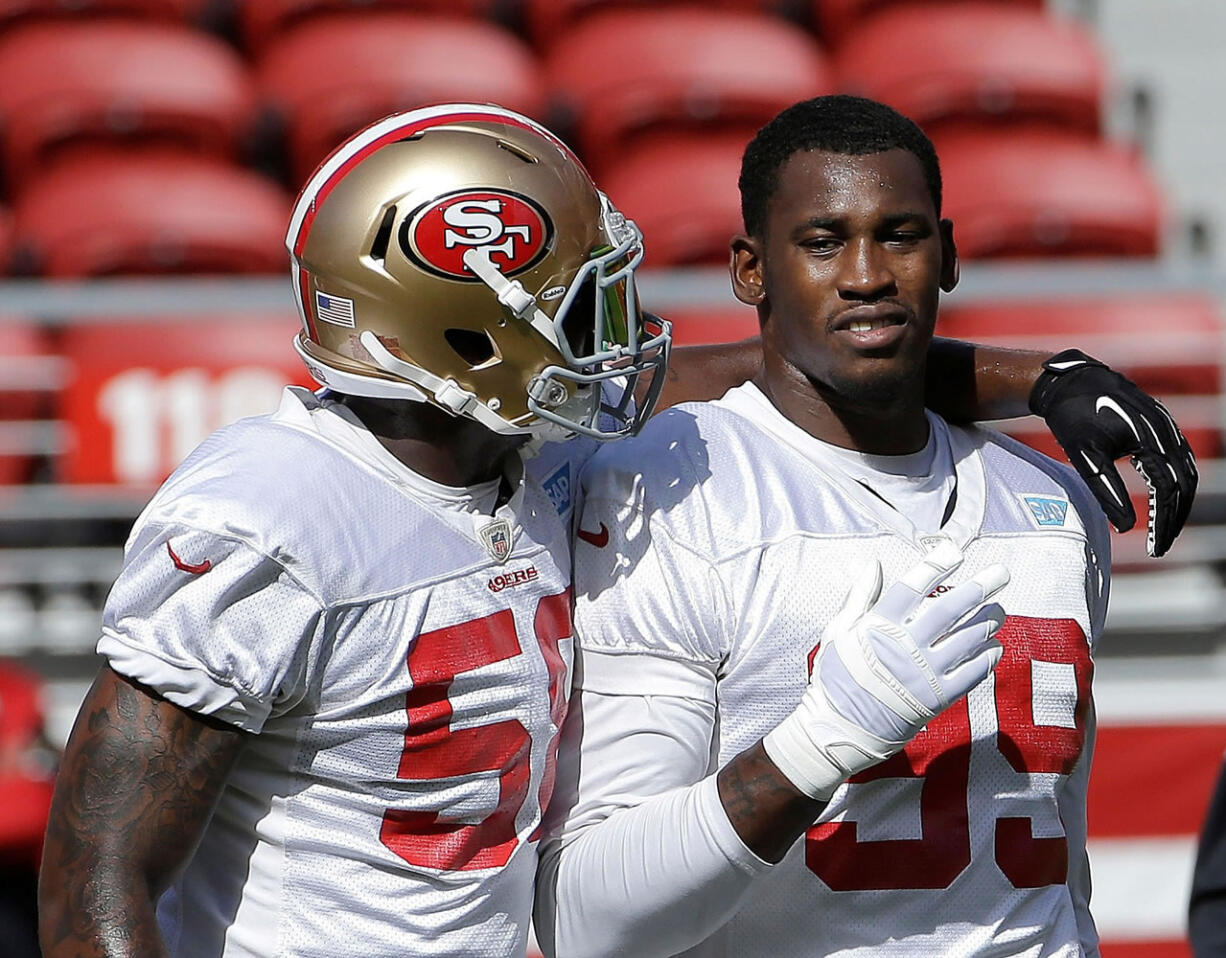 San Francisco 49ers linebackers Eli Harold, left, and Aldon Smith talk during the team's training camp in Santa Clara, Calif., on Sunday, Aug. 2, 2015.