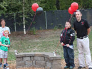 Image: Endeavour Elementary School fifth-graders Kyle Wilke, left, and Junior Martinez stand with Principal Lauren Hopson and Associate Principal Stuart Anderson next to the school's new &quot;Grizzly Bench,&quot; which is meant to be a safe place for students to sit during recess when they are in need of a friend to play with.