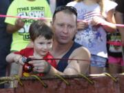 Grayson Pieske, left, and his father, Jordan Pieske, of Sandy, Ore., enjoy fishing from of a makeshift trout pond Saturday next to Pearson Air Museum.