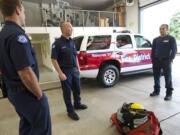 Fire District 3 firefighter Andrew Blomdahl, center, firefighter/paramedic Nolan Meyer, left, and intern Bryce Ponder talk to The Columbian about using the stationu2019s SUV inside the bay of Fire District 3 headquarters in Hockinson.