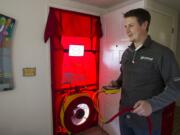 Revivial Energy Group's Robert Brierley conducts a pressure test to detect heat or cool air leaks as part of an energy audit in the Cascade Park home of Kaye and Monte Wolverton.