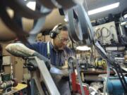 Eliot Smith sharpens a knife Tuesday in his shop at his home in Vancouver.