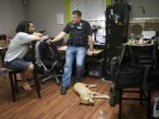 Adam Alexander, the owner of Grow Systems Northwest, is interviewed by Vancouver police officer Tom Topaum after a search warrant was executed at the business Thursday.