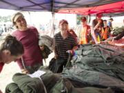 Photos by Steven Lane/The Columbian
U.S. Army veteran Paul Rodriguez-Navarro, left, and Navy veteran Dave Sommer pick up military surplus items Wednesday at the annual Veterans Stand-Down event at the Armed Forces Reserve Center.