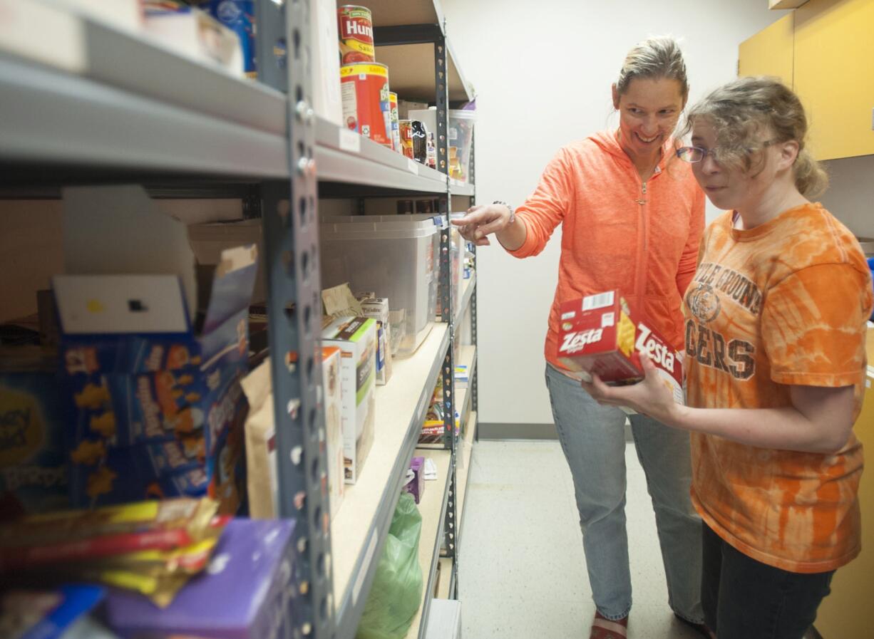 Teacher Niki Edgar helps student Sierra McIntyre organize a new pantry at Battle Ground High School in Battle Ground last week.