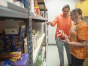 Teacher Niki Edgar helps student Sierra McIntyre organize a new pantry at Battle Ground High School in Battle Ground last week.