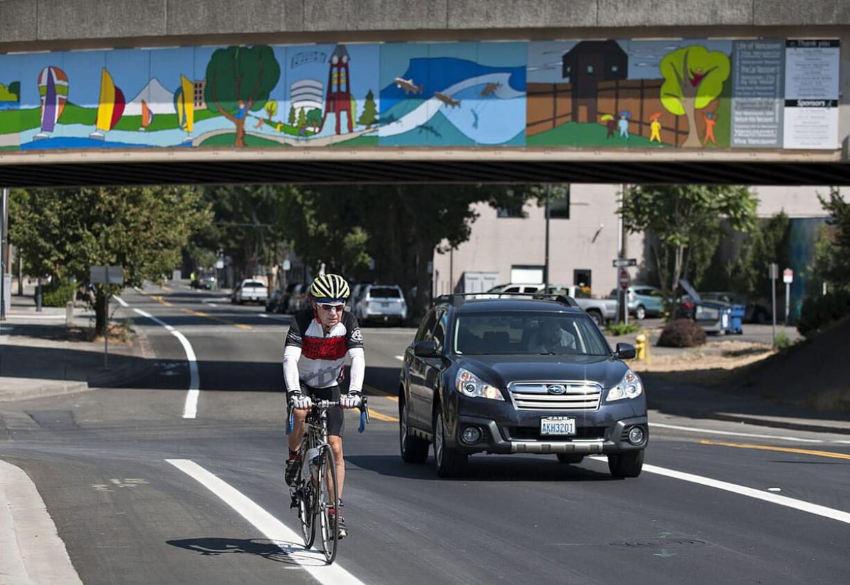 A cyclist rides along Columbia Street in downtown Vancouver as a motorist passes him Thursday morning, August 27, 2015.