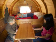 Photos by Steven Lane/The Columbian
Mick Robins sits at the pull-out table of his camper with his daughter, Pei, 15, while daughter Sadie, 11, rests on the bed.