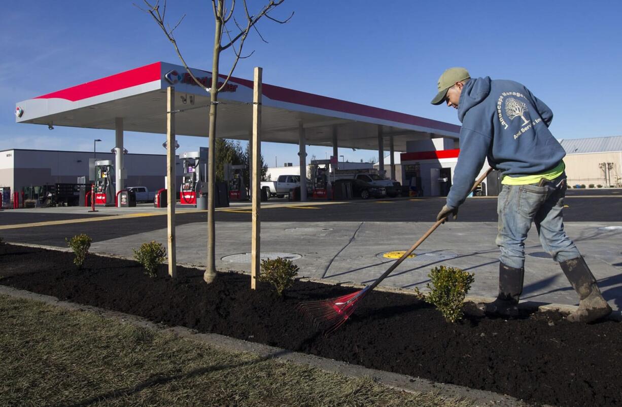 Vincente Garcia puts the finishing touches on the landscaping of a new Fred Meyer gas station in the North Salmon Creek neighborhood.