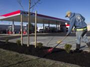 Vincente Garcia puts the finishing touches on the landscaping of a new Fred Meyer gas station in the North Salmon Creek neighborhood.