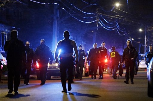 Police officers walk near a crime scene Friday, April 19, 2013, in Watertown, Mass.