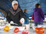 Master Gardener Jim Cave prepares samples at the Heirloom Tomato and Garlic Festival.