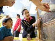 Photos by Steven Lane/The Columbian
American Honey Queen Susannah Austin talks about honey bees with Nivaran Sarki, 6, and his grandmother Kareen Messerschmidt, both from Vancouver, at the Clark County Fair Wednesday.