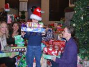 Esther Short: Riverview Bank employees and their families -- including , from left, Jessica Douglas, Jennifer Konopasek and son Austyn Konopasek, and Gina Williams -- donated nearly 400 gifts to foster children through the Shirley DuPaul Gifts for Kids in Care program.