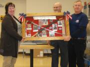 Northeast Hazel Dell: Debbie Quatier presents a military display donated from the Quatier family to the Rev. Jerry Keesee, center, and Jack Giesen, treasurer of the Vancouver Barracks Military Association.