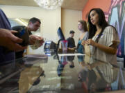 Sara Kemple, right, 25, a clerk at Main Street Marijuana, helps customers at the store in Vancouver's Uptown Village.