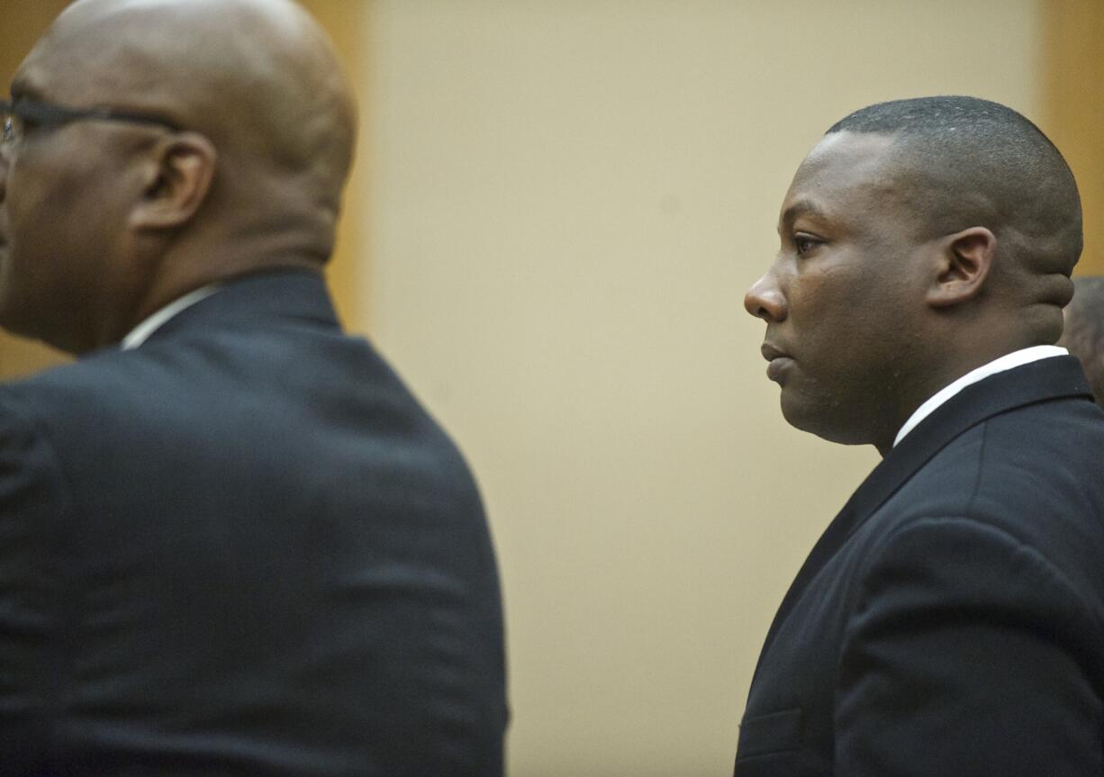 Former Beaverton police Officer Christopher Warren stands Monday as a jury enters the courtroom of Clark County Superior Court Judge Barbara Johnson, where he is being tried on a charge of first-degree child rape.