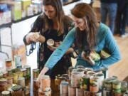 Crissaya Wood, left, and Meghan Ashton, seniors at Columbia Adventist Academy, sort donated food for The Children's Center during a volunteer outing Wednesday morning.