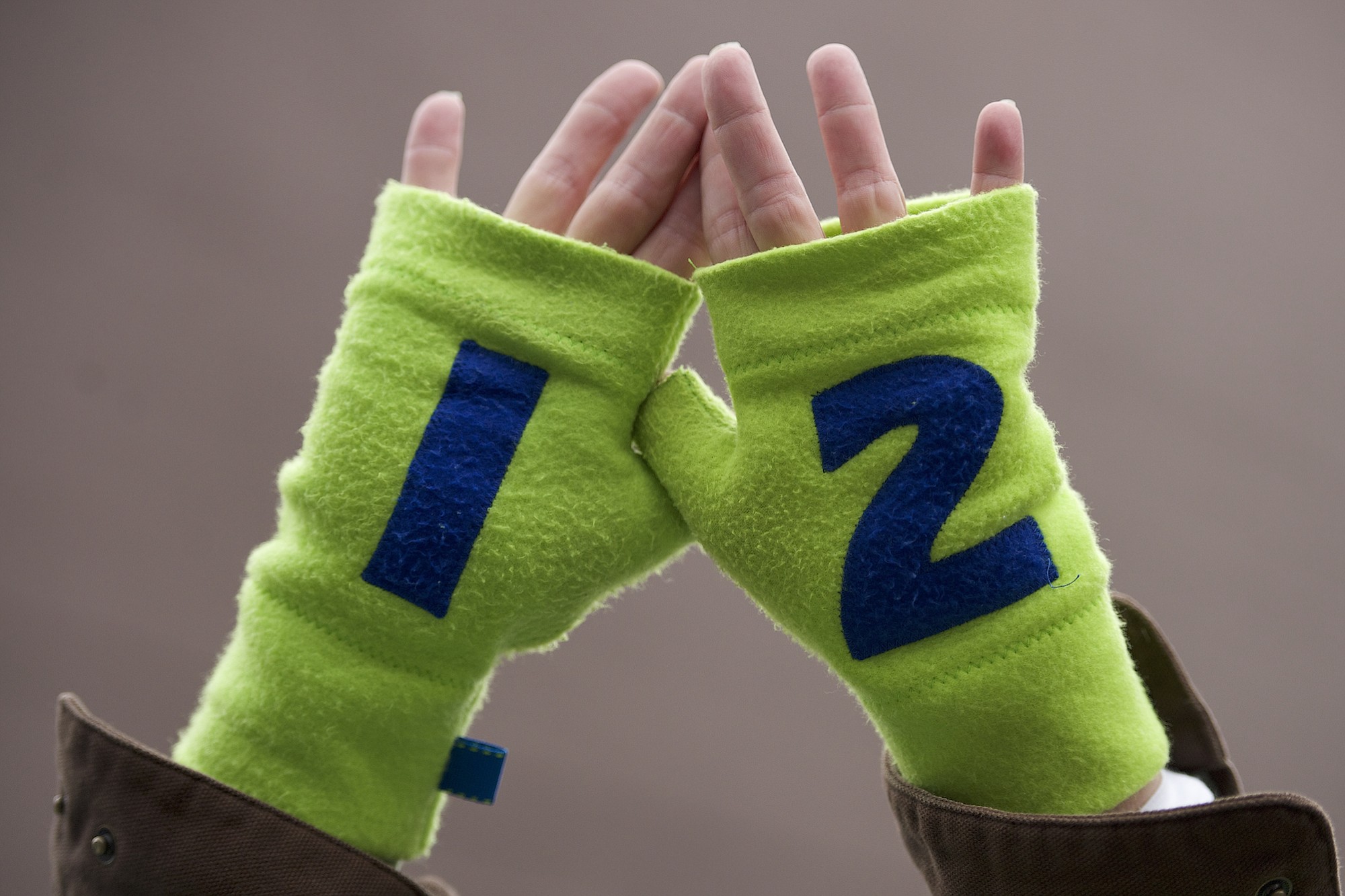 A Seattle Seahawks fan holds up 12th man gloves in support of the Seahawks before the start of the NFC Championship game at CenturyLink Field Sunday January 19, 2014 in Seattle, Washington.