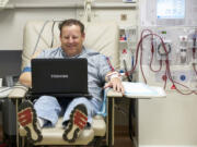 Photos by Steven Lane/The Columbian
Scott Warren passes the time on his computer during a recent four-hour dialysis session at DaVita Vancouver Dialysis Center. Warren's kidneys failed three years ago. Since then, he's been on a mission to find a living kidney donor.